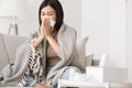 Sick at home. Girl blowing runny nose in napkin Royalty Free Stock Photo