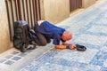 Sick homeless beggar on his knees on Old Town of Prague