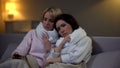 Sick homosexual female couple in scarf lying in bed, flu virus quarantine