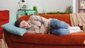 Sick ill woman suffering from period cramps, stomach ache menstrual pain lying on sofa at home room Royalty Free Stock Photo