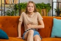 Sick ill woman suffering from period cramps, stomach ache menstrual pain lying on sofa at home room Royalty Free Stock Photo