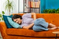 Sick ill woman suffering from period cramps, stomach ache menstrual pain lying on sofa at home room Royalty Free Stock Photo