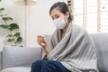 Sick, influenza asian young woman, girl wearing face mask in headache have a fever, flu and check thermometer measure body