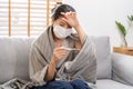 Sick, influenza asian young woman, girl wearing face mask in headache have a fever, flu and check thermometer measure body