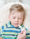 Sick kid with high fever laying in bed and mother checks the temperature Royalty Free Stock Photo