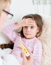 Sick kid with high fever laying in bed and mother taking temperature Royalty Free Stock Photo