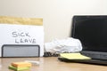 Sick leave message left on a messy office desk Royalty Free Stock Photo