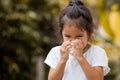 Sick little asian girl wiping or cleaning nose with tissue