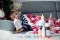 Sick little child, boy, with high fever sleeping on the couch at Royalty Free Stock Photo