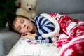 Sick little child, boy, with high fever sleeping on the couch at Royalty Free Stock Photo