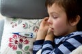 Sick little child, boy, with high fever sleeping on the couch at Royalty Free Stock Photo