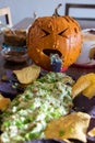 A sick looking pumpkin throwing up green stuff on a plate of chips Royalty Free Stock Photo