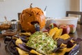 A sick looking pumpkin throwing up green stuff on a plate of chips Royalty Free Stock Photo