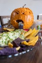 A sick looking pumpkin throwing up green stuff on a plate of chips Royalty Free Stock Photo
