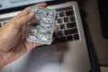 Sick male home office worker found an empty pill foil pack when needed most during the night before work deadline. Royalty Free Stock Photo