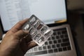 Sick male home office worker found an empty pill foil pack when needed most during the night before work deadline. Royalty Free Stock Photo