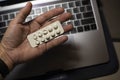 Sick male home office worker taking pills in front of his working space, during his working deadline night. Royalty Free Stock Photo