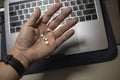 Sick male home office worker taking pills in front of his working space, during his working deadline night. Royalty Free Stock Photo