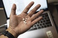 Sick male home office worker taking pills in front of his working space, during his working deadline night. Royalty Free Stock Photo