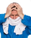 Sick man in a bathrobe wrapped in a towel over white background