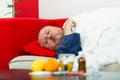 Sick man in bed with drugs and fruit on table Royalty Free Stock Photo