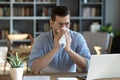 Sick man blow nose working at home workplace