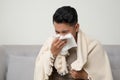 Sick man blowing nose and sneeze into tissue. Male have flu, virus or allergy respiratory