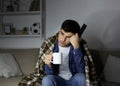 Ill man drinking tea and watching TV Royalty Free Stock Photo