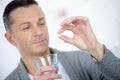 Sick man holding pill with glass water Royalty Free Stock Photo