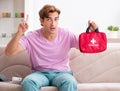 Sick man at home with first aid kit Royalty Free Stock Photo