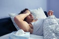 Sick man looking temperature in thermometer on bed Royalty Free Stock Photo