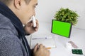 The sick man looks at the tablet. The gadget has a green screen instead of a monitor. The concept of remote health care and Royalty Free Stock Photo