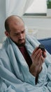 Sick man reading label of bottle with pills and drugs