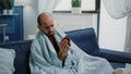 Sick man reading label of bottle with pills and drugs