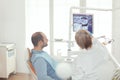 Sick man sitting on dental chair looking at teeth radiography