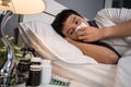 Sick man sneezing into tissue lying in bed Royalty Free Stock Photo