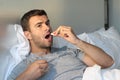 Sick man taking medicine in bed Royalty Free Stock Photo