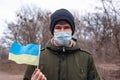 Sick masked man with ukraine flag.coronavirus outbreak in Ukraine. pandemic covid-2019