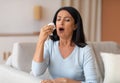 Sick mature woman sneezing and couching, holding tissue paper Royalty Free Stock Photo