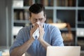 Sick millennial unhappy businessman suffering from seasonal allergy. Royalty Free Stock Photo