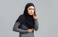 Sick muslim woman suffering from stomach pain, calling doctor for help Royalty Free Stock Photo