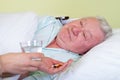 Sick old man in bed, receiving his pills Royalty Free Stock Photo