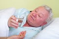Sick old man in bed, receiving his pills Royalty Free Stock Photo