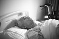 Sick old man lying in hospital bed alone Royalty Free Stock Photo