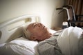 Sick old man lying in hospital bed Royalty Free Stock Photo