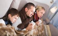 Sick parents and son under blanket