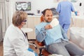 Sick patient inspecting teeth after dental surgery using mirror