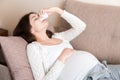 Sick pregnant woman blowing nose into tissue at home Healthy millennial healthcare concept