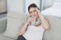 Sick pregnant woman sitting at home on the couch. She drinks a tablet dissolved in water