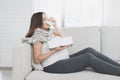 Sick pregnant woman sitting at home on the couch. She flies herself into a paper napkin.